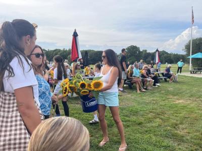 NonePeople passed out sunflowers among the crowd gathered at the sports complex. 