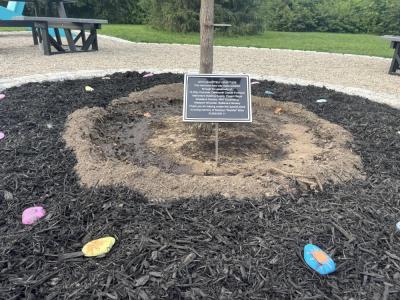 A plaque memorializes Madelyn, surrounded by painted rocks. 