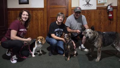 Dog trainers Cristina Fredette and Sherri Swindle, as well as Swindle’s husband, pose with their dogs. 
