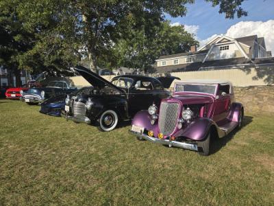 The cars were lined up in a row at the park lawn.