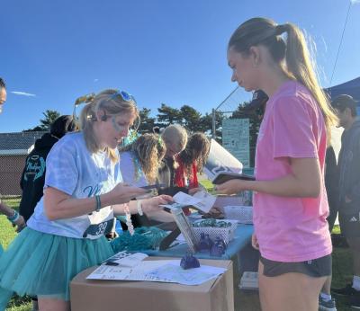 A runner picks up her number before the race.