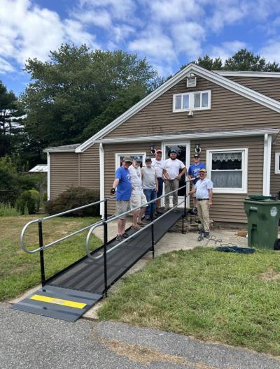 The Lions Club crew smiles around the completed ramp. 