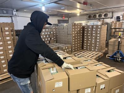 One employee prepares packages of sprouts for distribution. 