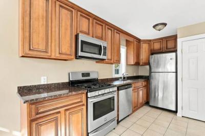 Wood kitchen cabinets with stainless refrigerator, microwave and range at 17 Beeden Road, Westport, MA