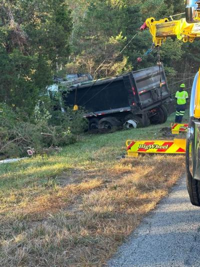 A crew drags the crashed truck out of the woods. 