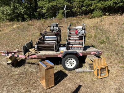 Several older pieces of dry harvesting equipment are displayed on the farm.