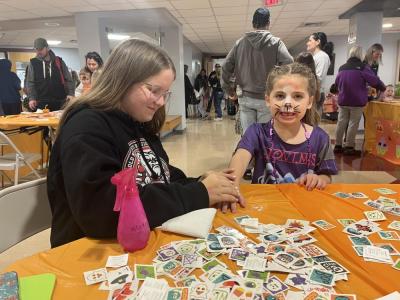 Annika Lund, left, applies a temporary tattoo on 5-year-old Scout Elder's hand. 