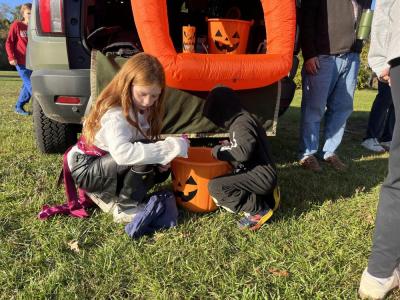 Kids take candy from one of the decorated car displays. 