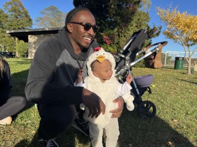 E J Bennet holds his daughter Eliana, 11 months, at the event. 
