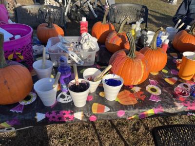 Pumpkins and paint line a table. 