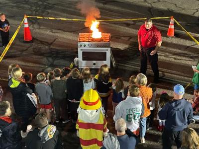 Captain Brooks Wilson demonstrates how to put out a cooking fire at the Oct. 9 open house. Photos source: Marion Fire Department