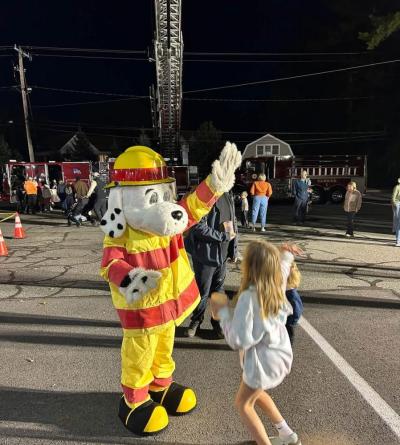 Kids high five the fire department's mascot. 