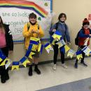 Fifth grade students Fiona Payne, Wyatt Churchill, Jacqueline Cobler and William Lucy hold the banner they helped to create.