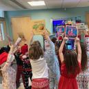 Mrs. Lenahan's first grade class holds up their book selections.
