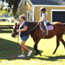 Rochester resident Molly Beson, 8, takes a guided ride on a horse.
