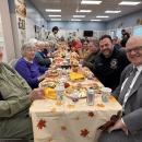 Senior citizens smile at their Thanksgiving lunch.