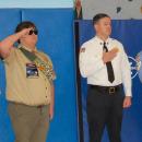 Boy scouts and police officers honor the flag.
