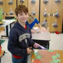 One student smiles with his craft.