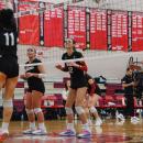 Molly Morrison, Piper Newell, and Molly Franco step up to the net to get ready for a block.