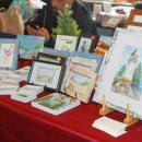 Leslie Geil shares her watercolors across the table.