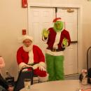 Santa, the Grinch and carolers join together to sing. 