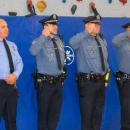 Police officers salute the flag. 