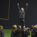 The cheerleaders pose in a stunt.