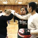 Mattapoisett Officer Linera Lima helps self-defense class attendees Leilani DePina and Joseline Lima learn how to defend themselves in a hair-pulling scenario in February. Photo by Grace Ann Natanawan