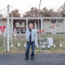 Carrier stands in front of his decorated home. Photo by Grace Roche
