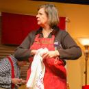 Michele Letourneau, as Emily, cleans a glass while chatting with her family. 