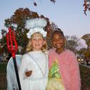 Ivy Stewart, 8, as a half angel-half devil and Nina Lyman, 8, as Princess Tiana at the Mattapoisett Halloween parade smile together. Photo by Mari Huglin 