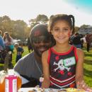 Faith, age 6, and Ray Leslie smile for a photo as they paint a pumpkin together at the Marion Trunk-or-treat. Photo by Mari Huglin 