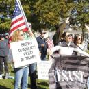 Emily Nugent of Mattapoisett holds a poster encouraging attendees to "Protect Democracy" while Avery Nugent holds a "Resist" flag at the Mattapoisett "No Kings" protest on Saturday, Oct. 18. Photo by Grace Ann Natanawan