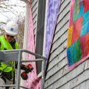Matt Moyer Bell, Massachusetts Design, Art, and Technology Institute's programs coordinator, installs part of the “Being Seen” display outside the Marion Art Center on Wednesday, Jan. 14. Photos by Grace Roche
