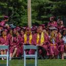 Graduates sit on the Old Colony field. 