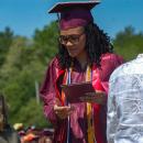 A student leaves the stage, diploma in hand. 