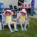 Three-year-old twins Rachel, left, and Hailey kick back at the car show. 