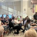 People crowded the meeting, split between attendees who supported and questioned the school's response. 