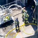 Firefighters man the hoses. 
