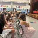 NoneSixth grade students listen as their classmate speaks during the graduation. 