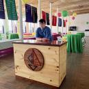 Josh Van Inwegen stands behind the welcome desk he built for the Community Boating Center of New Bedford.