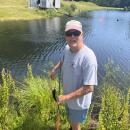 Woody Hartley holds up a bass he caught in the pond. 