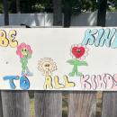 One sign features smiling flowers with a kind message. 