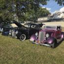 The cars were lined up in a row at the park lawn.