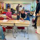 Students find their new desks. 