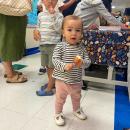 Holly, 1, plays with her lollypop while her mother directs new students and their parents to classrooms. 