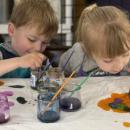 2 Children diligently painting 