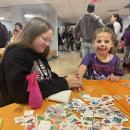 Annika Lund, left, applies a temporary tattoo on 5-year-old Scout Elder's hand. 
