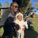 E J Bennet holds his daughter Eliana, 11 months, at the event. 