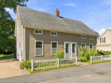 Front of the duplex at 17 Beeden Road in Westport, MA, with a white picket fence and double front doors